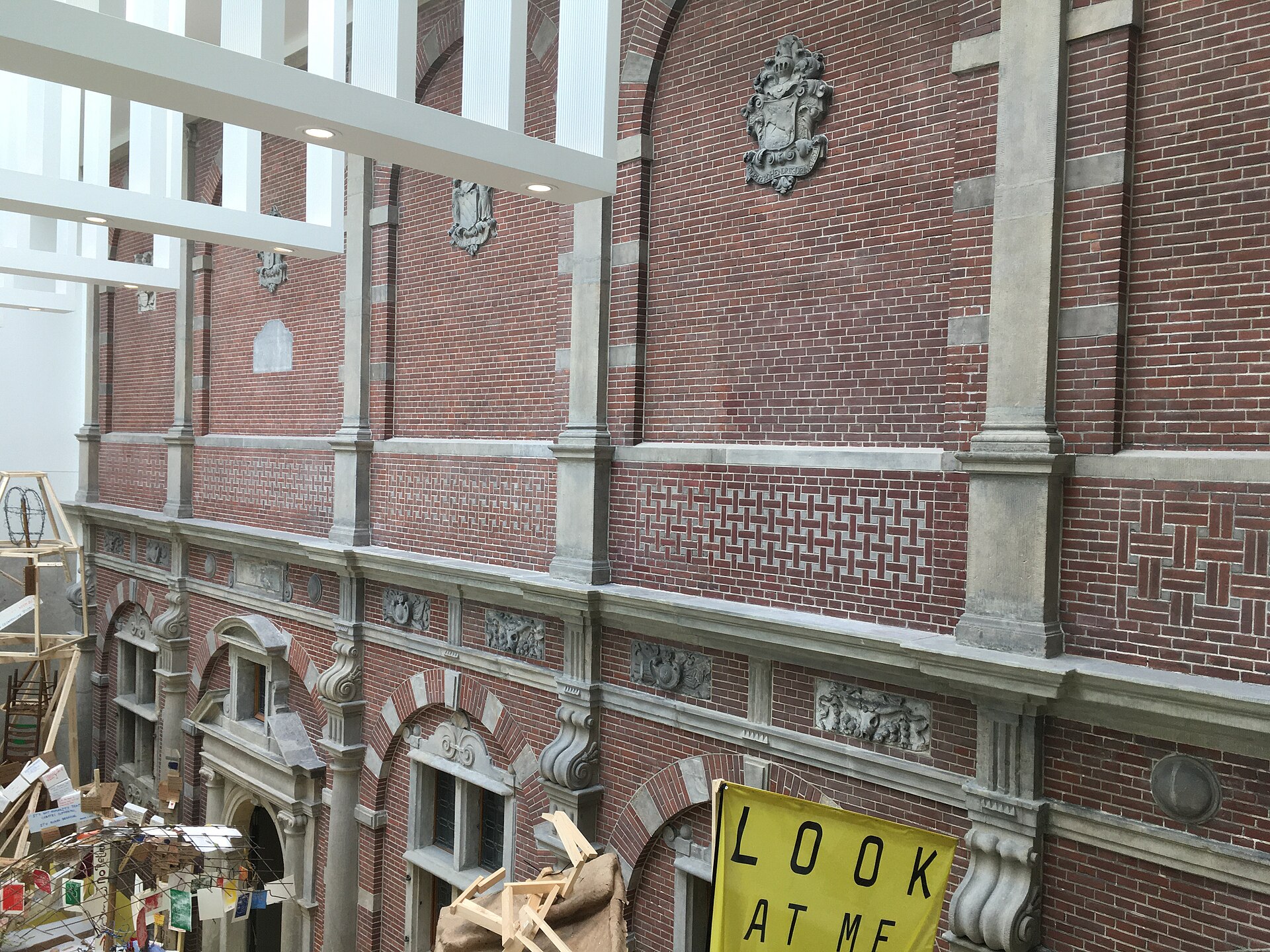 The brick inner wall of the Philips Wing with carved gable stones and architectural fragments set into it