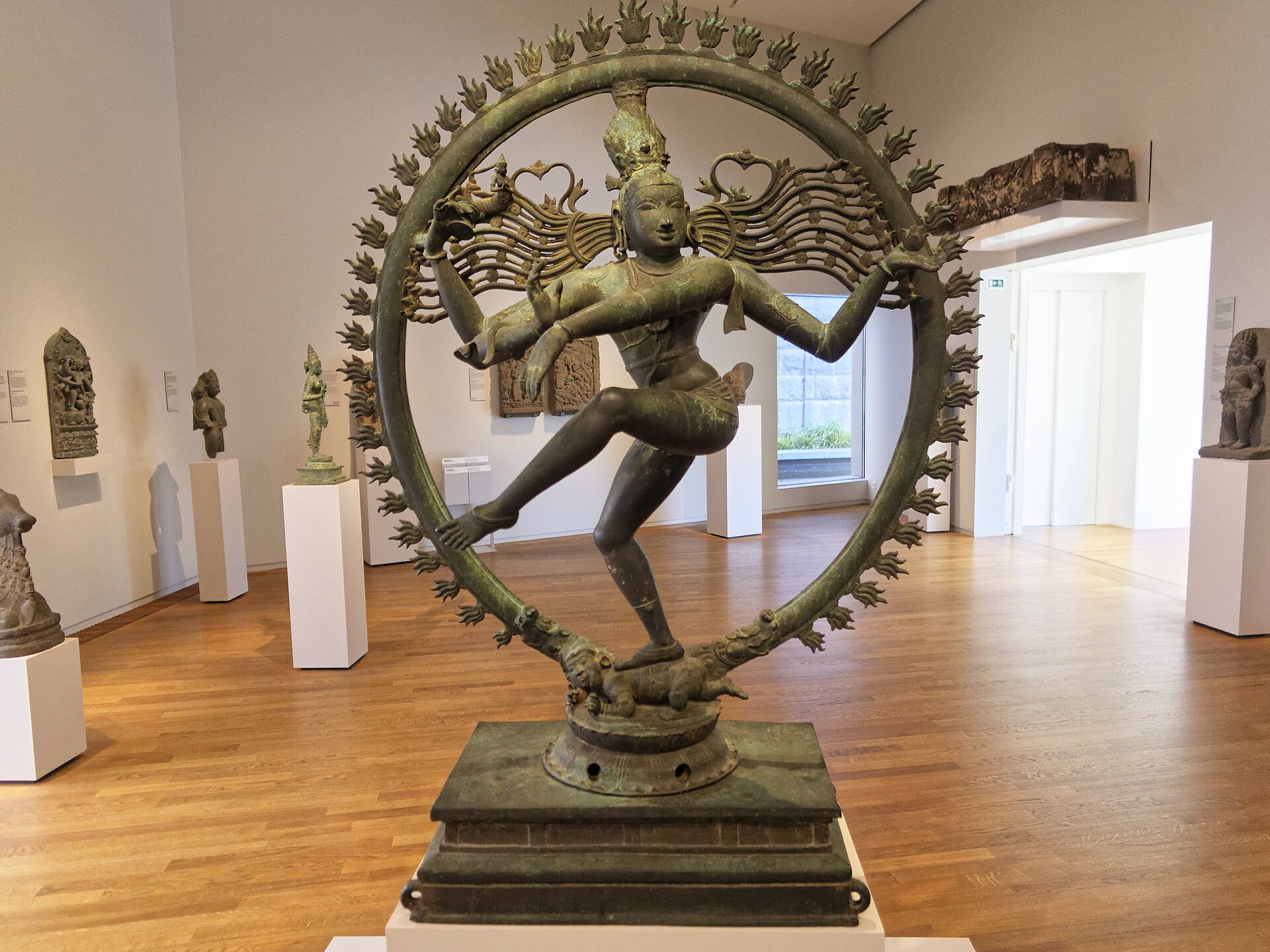 A large bronze dancing Shiva in a ring of flame, standing free in a white gallery of the Asian Pavilion