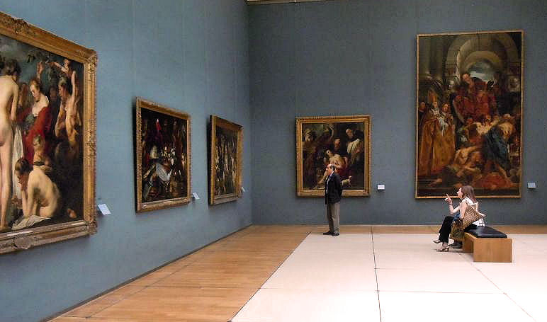 A blue-walled gallery hung with large Flemish Baroque paintings by Jacob Jordaens