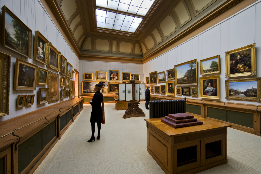 Paintings hung salon-style beneath a glass skylight in the First Painting Gallery at Teylers Museum