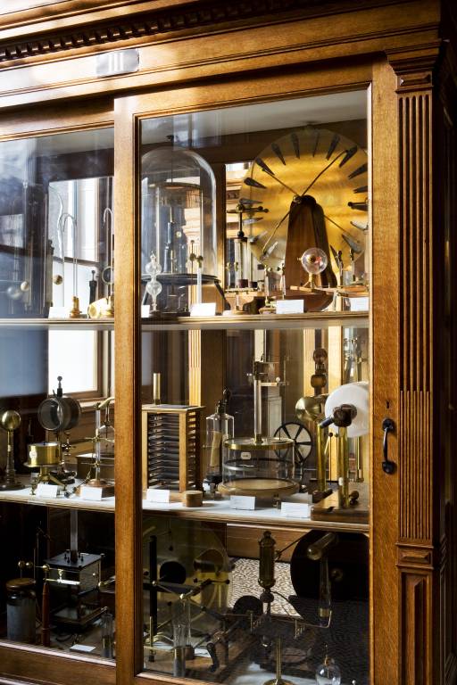 A glass-fronted cabinet of 19th-century scientific instruments in the Instrument Room at Teylers Museum