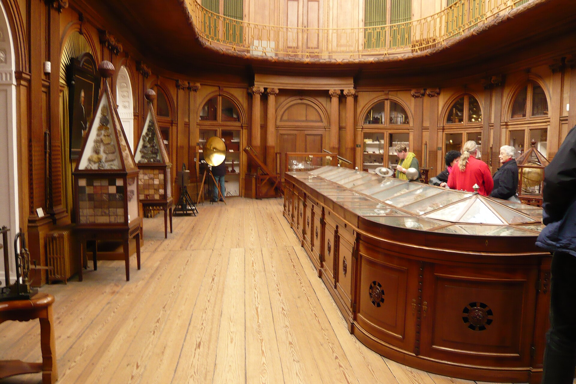 The curved wooden gallery and display cabinets of the Oval Room at Teylers Museum