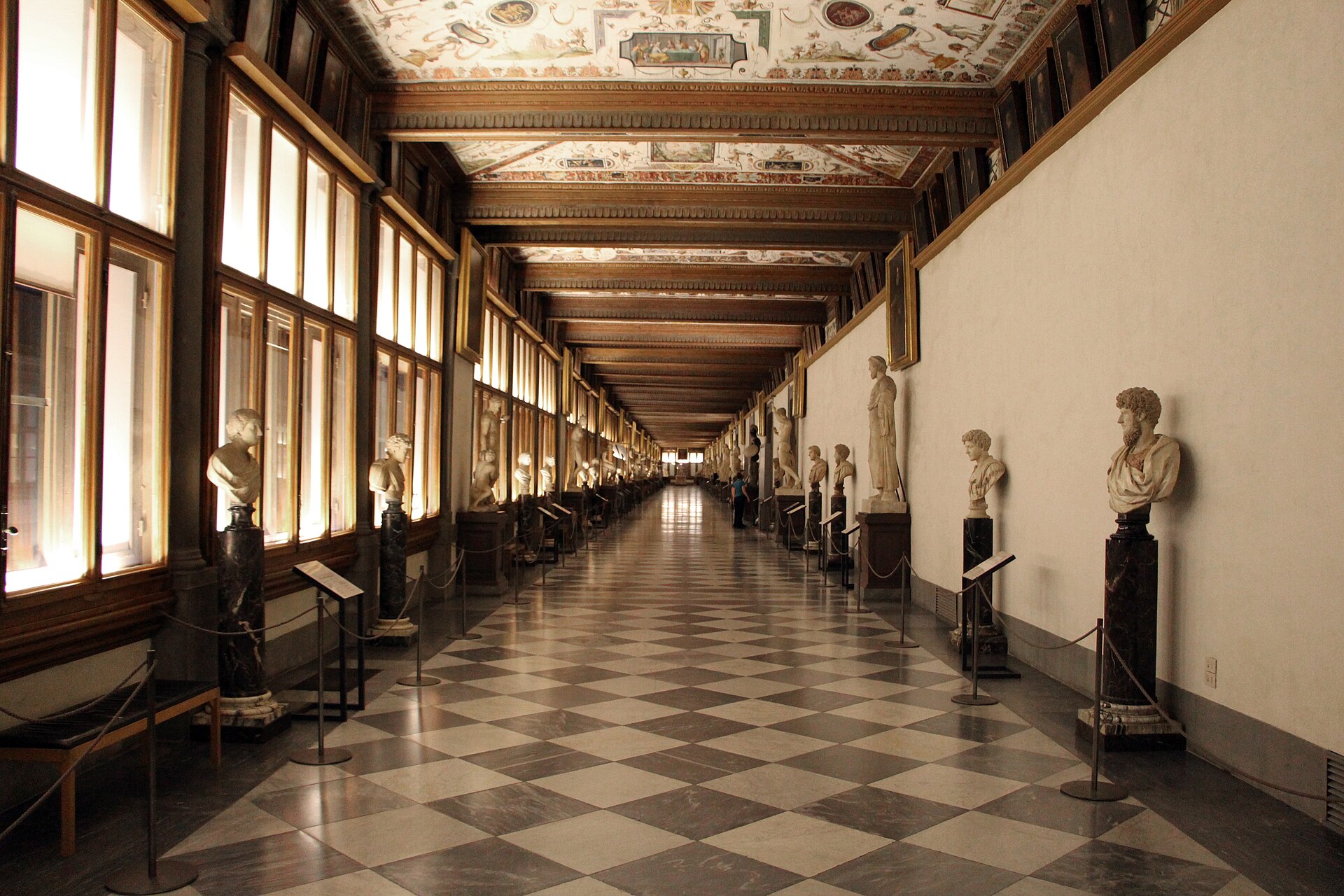The Uffizi's eastern corridor, checkerboard floor, painted grotesque ceiling and a double row of ancient marble busts