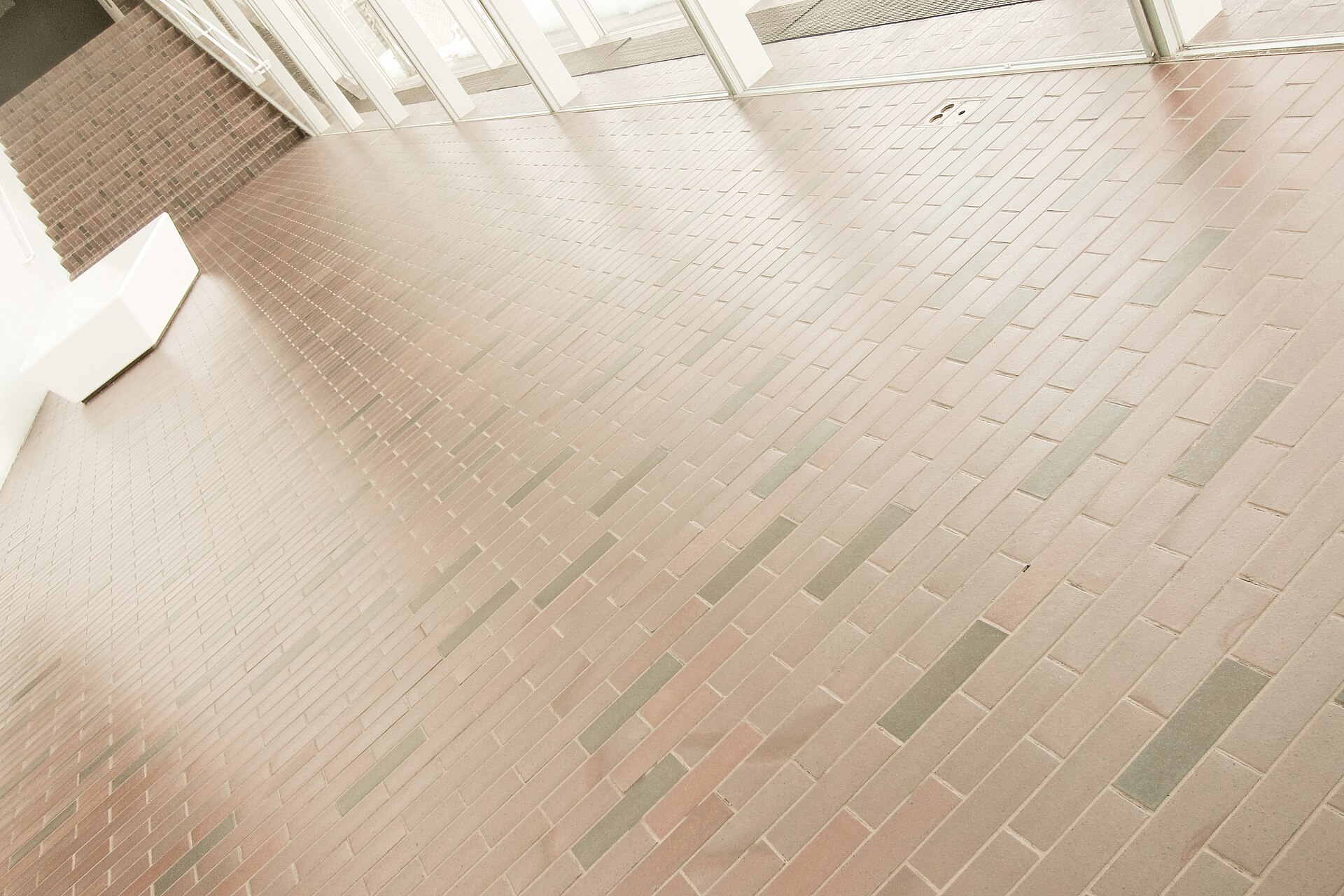 A brick-patterned terrazzo floor and glass wall inside the 1971 Barnes building