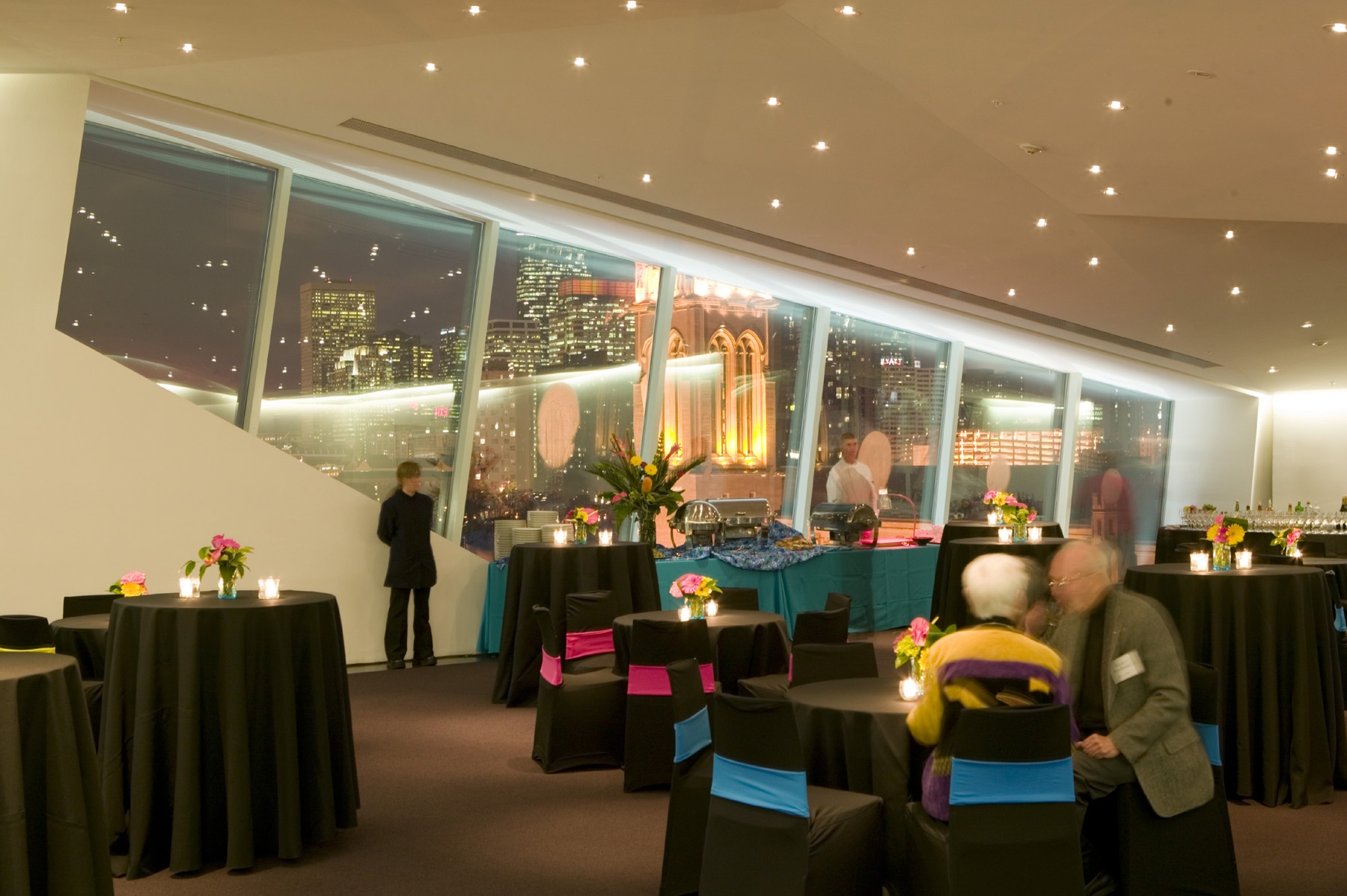 The Skyline Room at night, set for an event, with the Minneapolis skyline through the glass wall