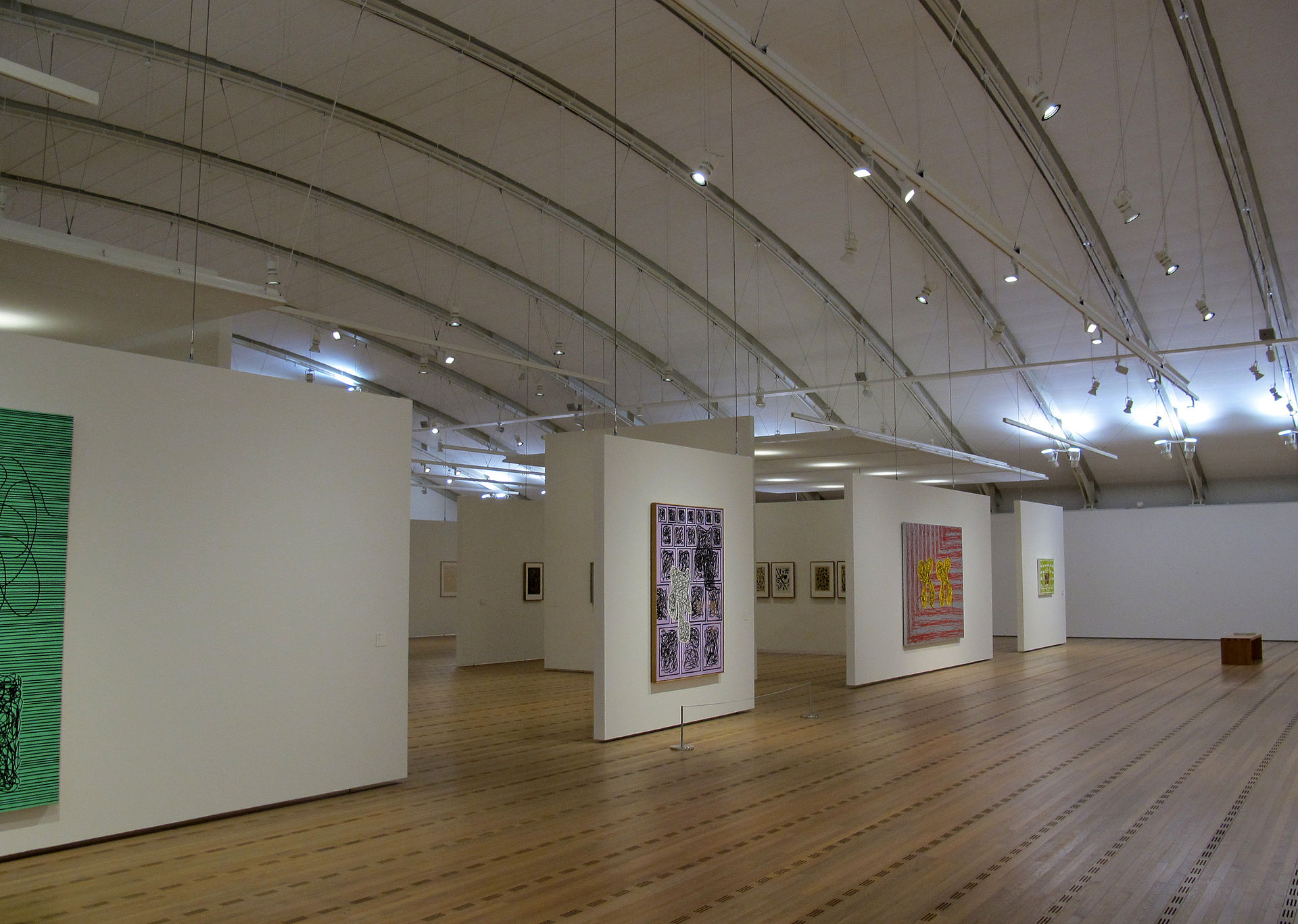 A gallery inside Zentrum Paul Klee, works on paper hung on freestanding walls under the vaulted roof